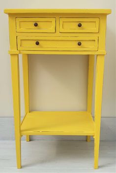 a small yellow table with two drawers