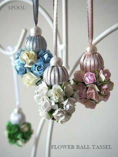 three ornaments hanging from a tree with flowers in them and the words flower ball tassel