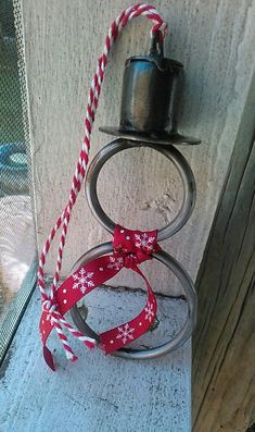 a candle holder with a red and white ribbon tied around it on the side of a building