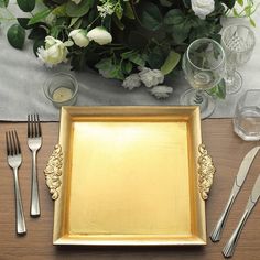 there is a gold plate with silverware on the table