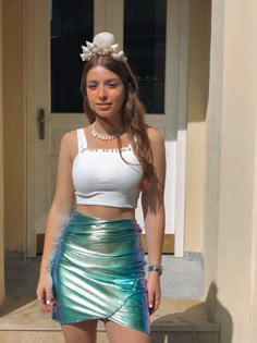 a young woman in a white top and green skirt