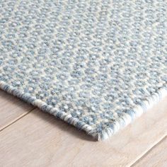 a blue and white rug on top of a wooden floor next to a wood floor