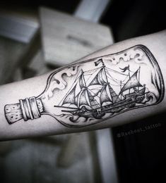 a ship in a bottle tattoo on the arm