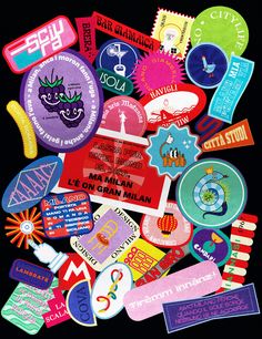 a pile of colorful stickers on top of a black surface with words and symbols all over them