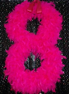 a pink feather wreath on top of a black table