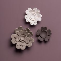 three flower shaped dishes on a purple surface