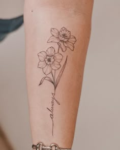 a woman's arm with flowers on it and the word love written in cursive writing