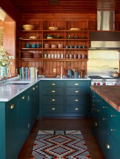 a kitchen with blue cabinets and white counter tops is pictured in this image, the rug has been placed on the floor