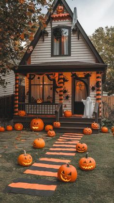 a house decorated for halloween with pumpkins on the lawn