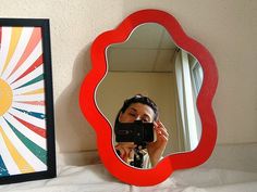 a woman taking a photo in front of a mirror