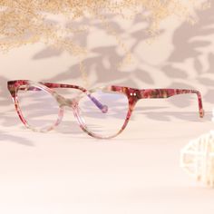 Embrace the perfect blend of sophistication and style with our two-tone cat-eye frames. Made from high-quality acetate, these glasses showcase a unique and captivating design. The combination of the cat-eye shape and the two-tone color scheme adds a touch of elegance and individuality to your look. The inclusion of spring hinges provides flexibility and comfort, ensuring a perfect fit for any face shape. Whether you're enjoying a sunny day by the beach or attending a glamorous soirée, these glasses will enhance your style and make you stand out from the crowd.Weight: 27 gFrame Shape: Cat EyeFrame Color: RedFrame Material: AcetateRim Type: Full RimSpring Hinge: YesAdjustable Nose Pads: NoWeight: 27 gLens Width: 54 mmBridge Width: 14 mmTemple Length: 145 mmFrame Width: 139 mmLens Height: 45 Purple Glasses, Eye Frames, Eye Shape, By The Beach, Cat Eye Frames, Glasses Online, Spring Hinge, Eye Shapes, Face Shape