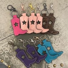 four pairs of cowboy boots with stars on them are shown in the shape of key chains