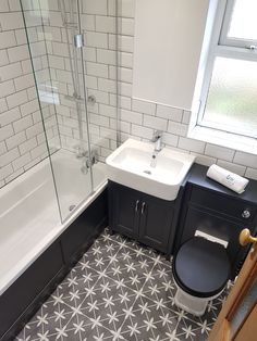 a black and white tiled bathroom with a toilet, sink, shower stall and bathtub