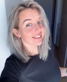 a woman with grey hair is taking a selfie