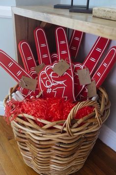 a basket filled with lots of red handprints and paper hearts on top of a wooden table