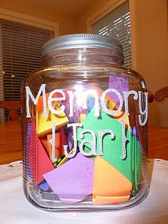 there is a glass jar with many different colored papers in it that says memory jar