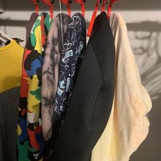 several shirts hanging on clothes racks in a closet