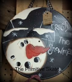 the primitive skateboard is decorated with a snowman