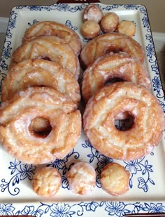 glazed doughnuts on a blue and white plate with floral design around the edges