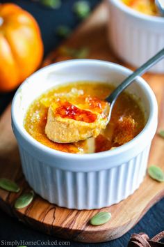 a spoonful of soup with pumpkins in the background