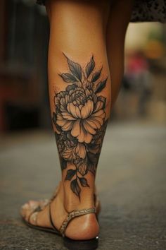 a woman's foot with flowers on it and leaves around her ankles, as well as the bottom part of her leg