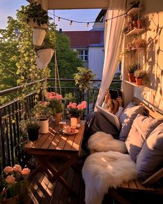 a woman taking a photo on her phone while sitting on a balcony with potted plants