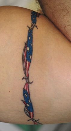 an american flag tattoo on the back of a man's arm with scissors in it