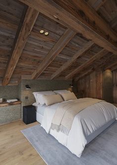 a large bed sitting inside of a bedroom on top of a hard wood flooring