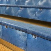 some blue seats are lined up in the stands