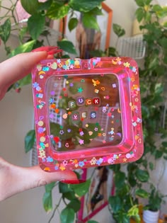 a person holding up a pink plastic case with colorful stickers on it