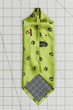 the necktie is made up of green fabric with black and white designs on it