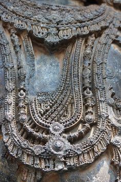 an intricately carved stone sculpture with multiple designs on it's face and neck