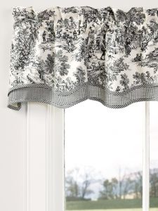 the window is decorated with black and white floral curtains, which are hung in front of an open window