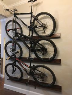 there is a bike mounted to the wall in this room with two bikes on it