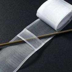 a roll of toilet paper with a bamboo stick sticking out of it next to some mesh