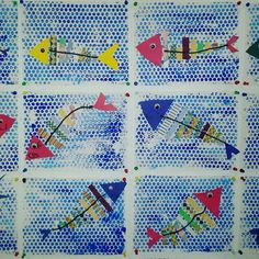 four different colored fish on blue and white paper