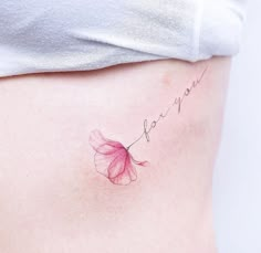 a woman's stomach with a pink flower tattoo on her belly that says, i love you