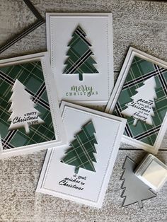 three cards with christmas trees on them sitting next to a stamper and some scissors