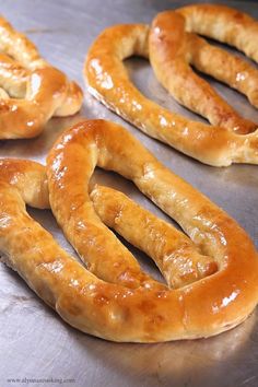 some pretzels are sitting on a metal surface and ready to be baked in the oven