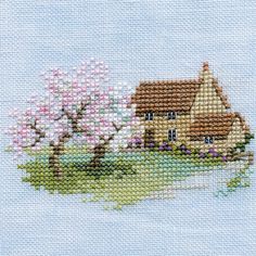 a cross stitch picture of a house and tree