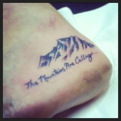 the mountains are calling tattoo on someone's leg