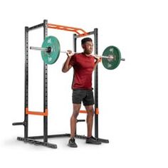 a man standing in front of a squat machine with one hand on the barbell