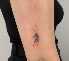 a woman's arm with a small bug tattoo on the left side of her arm