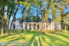 a large white house surrounded by trees and grass