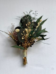 a bouquet of flowers on a white background with green leaves and dried flowers in the center