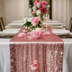 the table is set with pink flowers and silverware