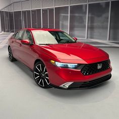 a red car is parked in an empty room with no people or vehicles around it