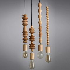 several wooden objects hanging from strings with light bulbs