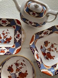 four plates and a teapot with designs on them