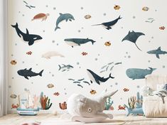 a child's room with an ocean theme wallpaper and stuffed animals on the floor